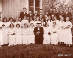 Mācītājs Gustavs Špērs ar Nīcas iesvētāmiem jauniešiem 1934.g. 6.maijā. Alvīne Dobele 2. rindā ceturtā no labās. Viena no pirmā rindā sēdošajām jaunkundzēm Made Sneibe (dz.Pieče).