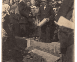 1933. gads. Dunikas Golgātas Brāļu draudzes baznīcas pamatakmeņa svētki. Priekšplānā redzami sludinātāji: Ad Zvagulis, H. Auders, J. Jaunciems. P. Jankaitis patreiz ievieto piemiņas kārbu pamatos.