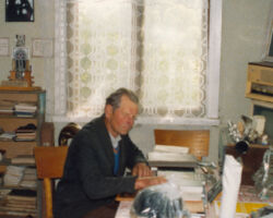 Kārlis Janeks pie sava galda 14. jūlijā, mācītāja bildē  redzams Plāte Sr labajā stūrī. Gorbačova bilde stūrī.