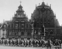 Vācu kājnieki soļo garām "Schwarzhaupter" māja (Melngalvju namam) Rīgā, 1917. gada septembrī.